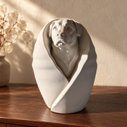 Front of chalk off-white wrapped dog urn on dark walnut