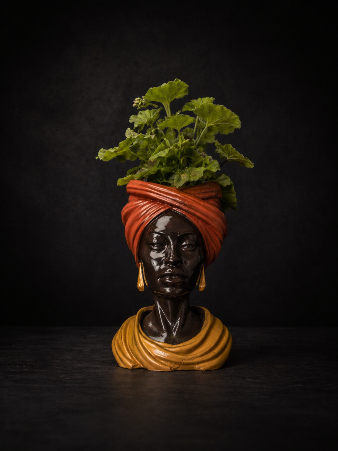 Golden Hour cast stone head planter with green plant on moody black background