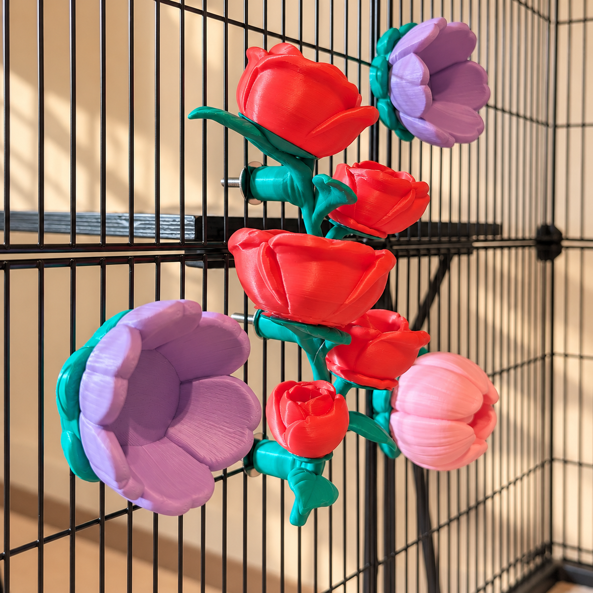 Oblique view of the rose vine, two purple flower cups and pink flower cup mounted on a cage