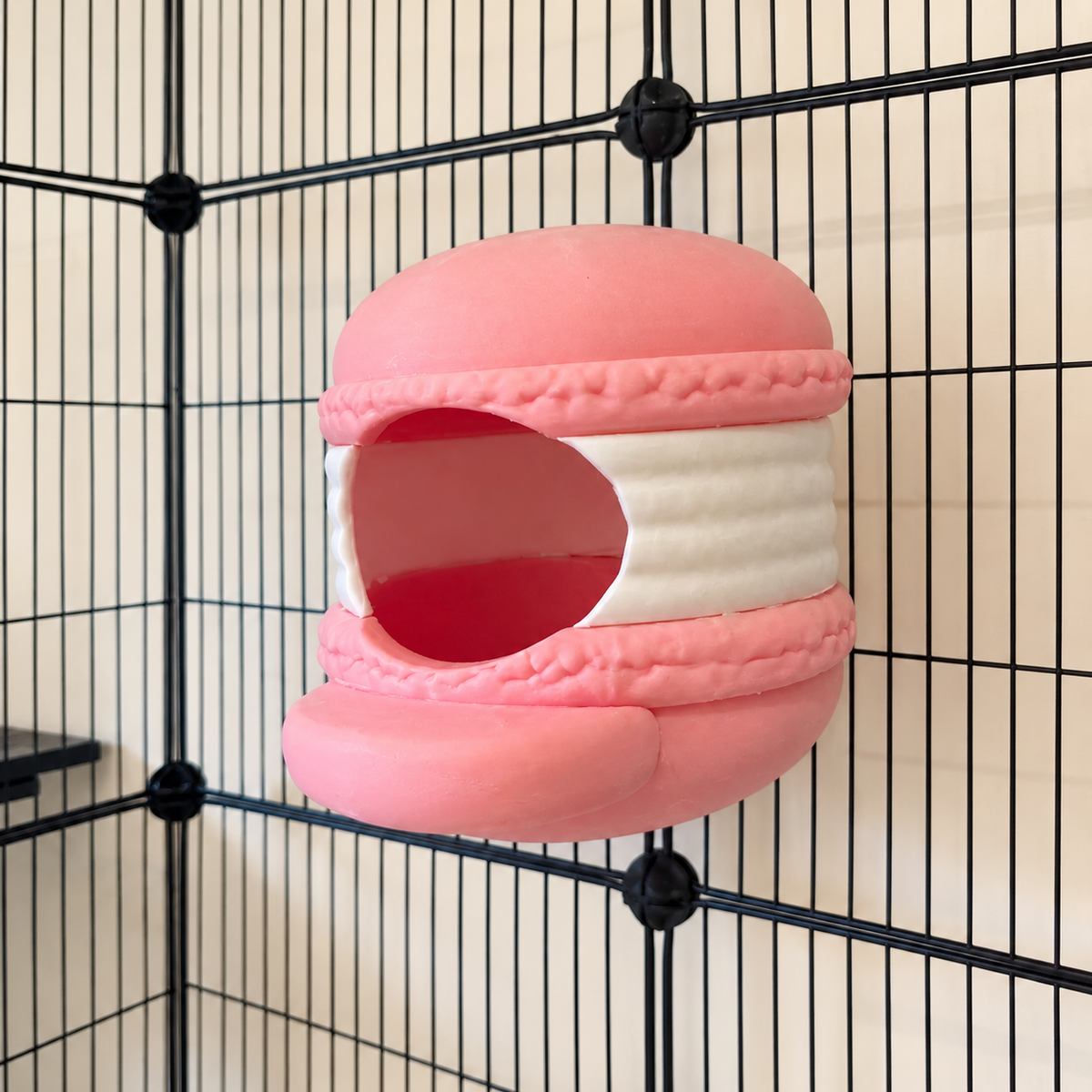Empty pink and white macaron hide viewed from the side in a cage.