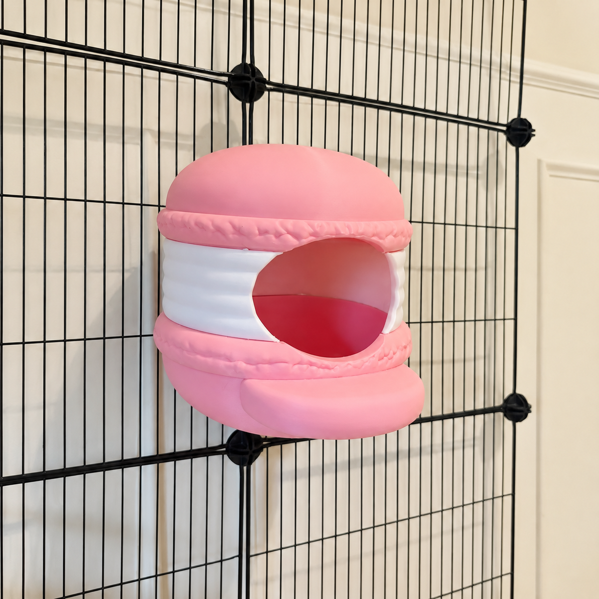 Opposite three-quarter view of a pink and white macaron hide and its open entrance.
