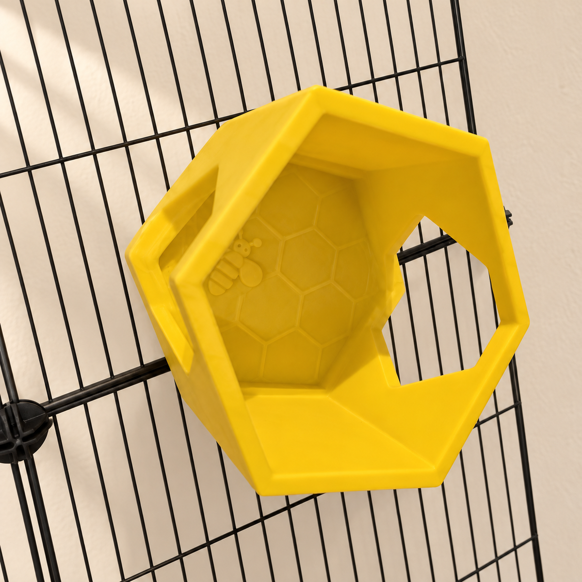 Angled close view of one yellow honeycomb shelf, showing its raised rim, bee relief and side opening.