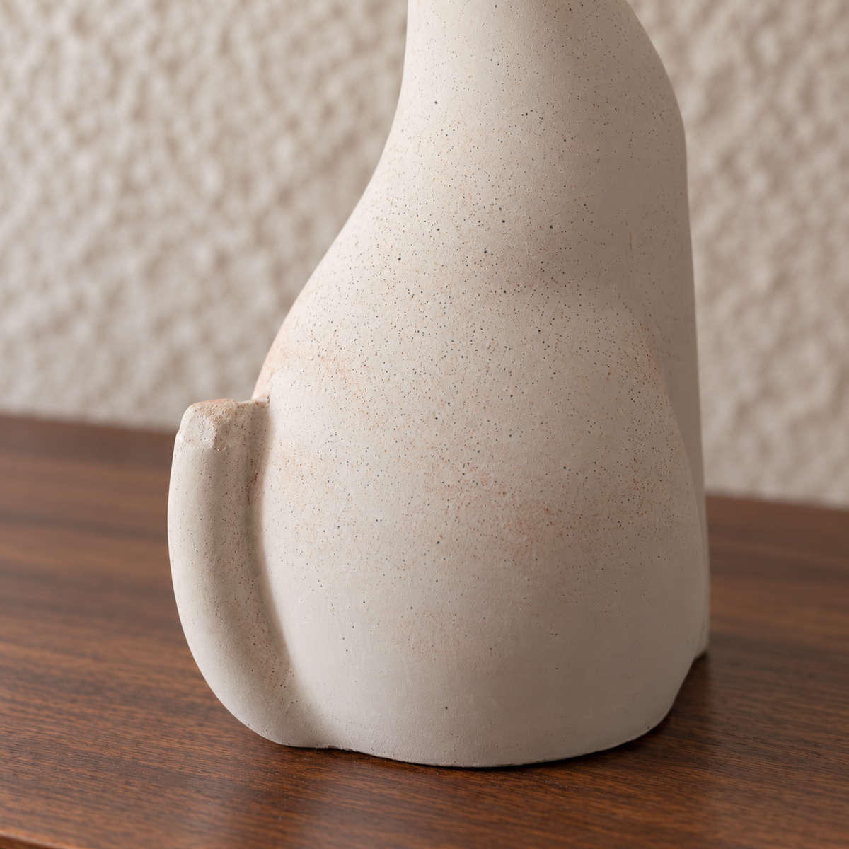 Pale modernist cat urn, curved tail detail.