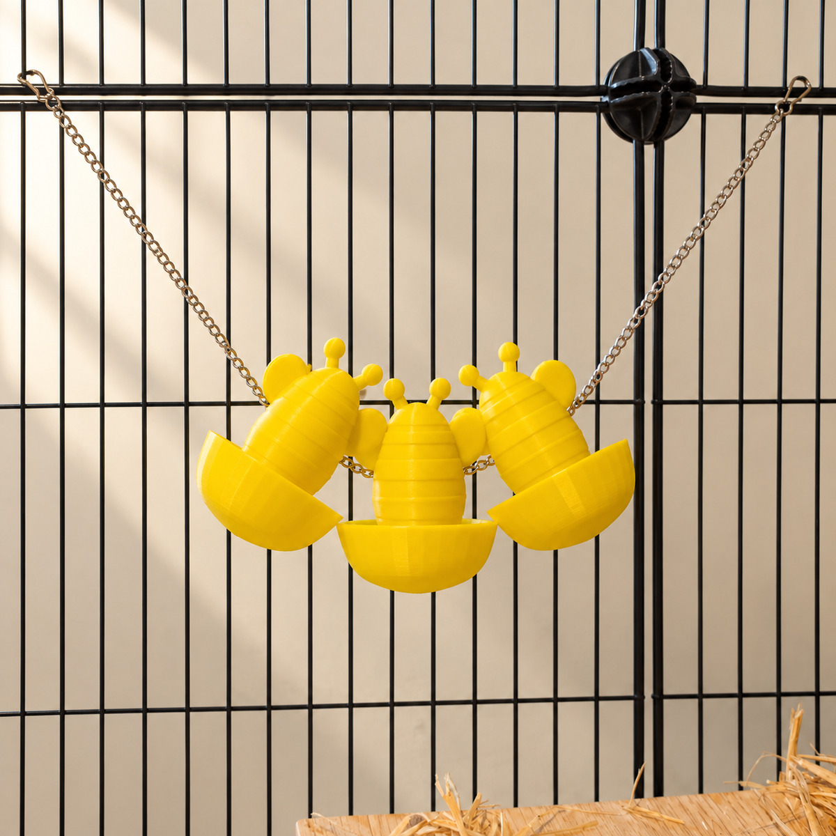 Three yellow bee-shaped forage cups hanging from one metal chain with hooks at both ends.