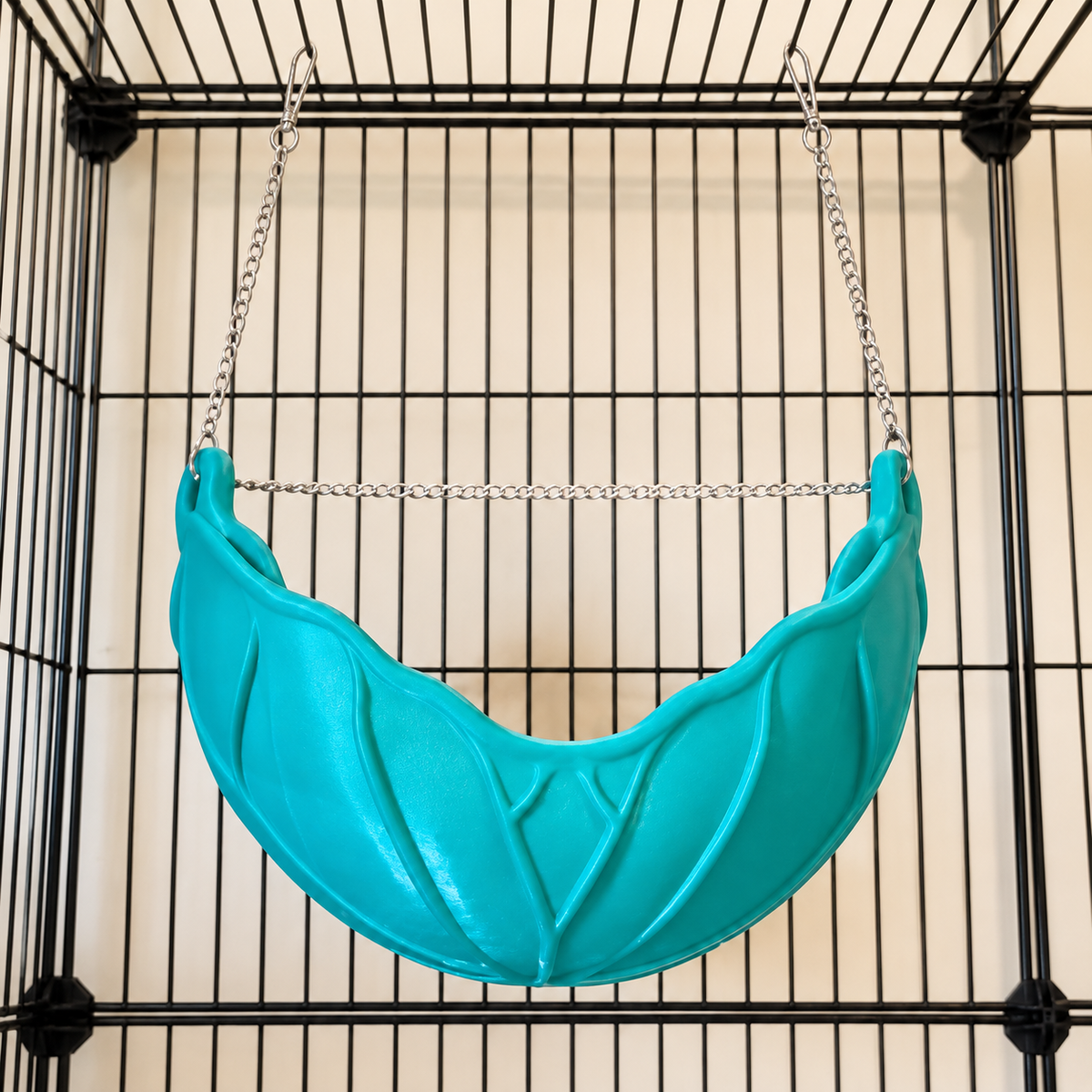 A lower front view of the empty green leaf hammock and its actual hanging chain and clips.