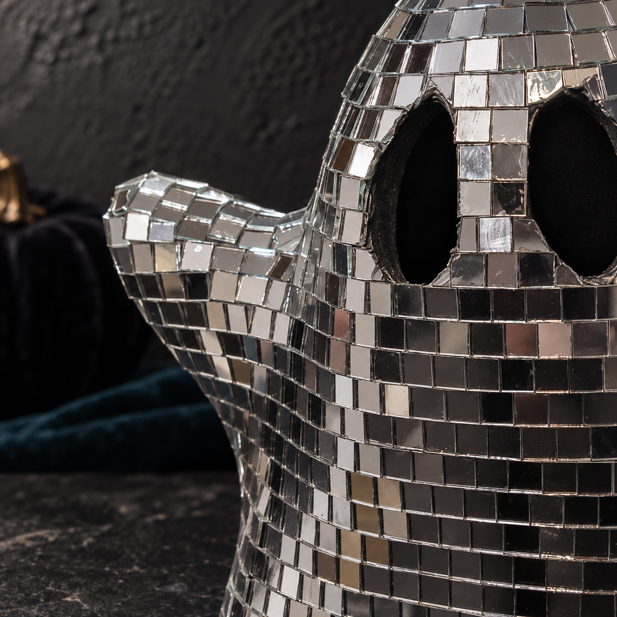 Close-up of the individual silver glass mirror tiles around the ghost’s eye openings and raised arm.