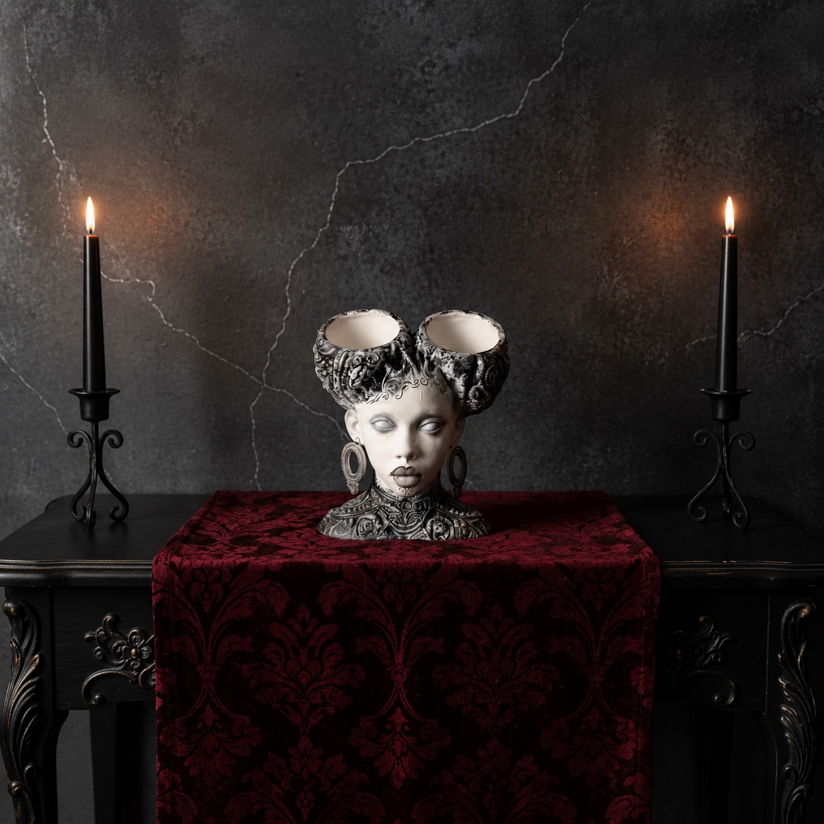 Unplanted gothic twin bowl head planter on red velvet between two candles