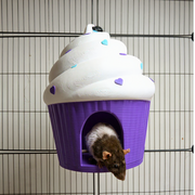 Purple and white cupcake rat hide mounted in a wire cage with a rat at the entrance