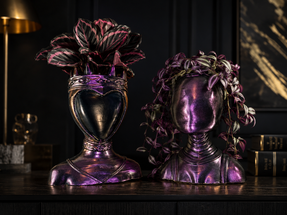 Queen and Oracle cast stone bust planters on dark interior shelf