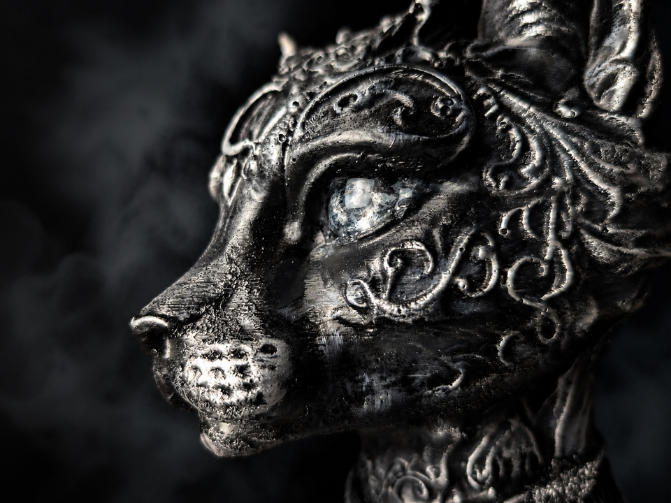 Close detail of sculpted cat face and pale eye finish