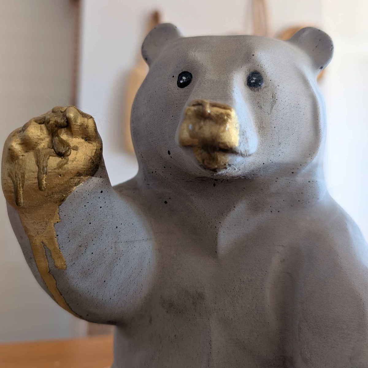 Front close-up of honey bear ornament showing gold muzzle, paw and feet