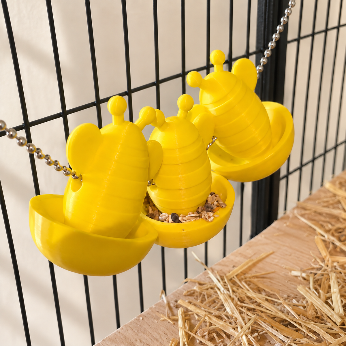 Three yellow bee forage cups with dry food in the middle bowl, viewed from above at an angle.