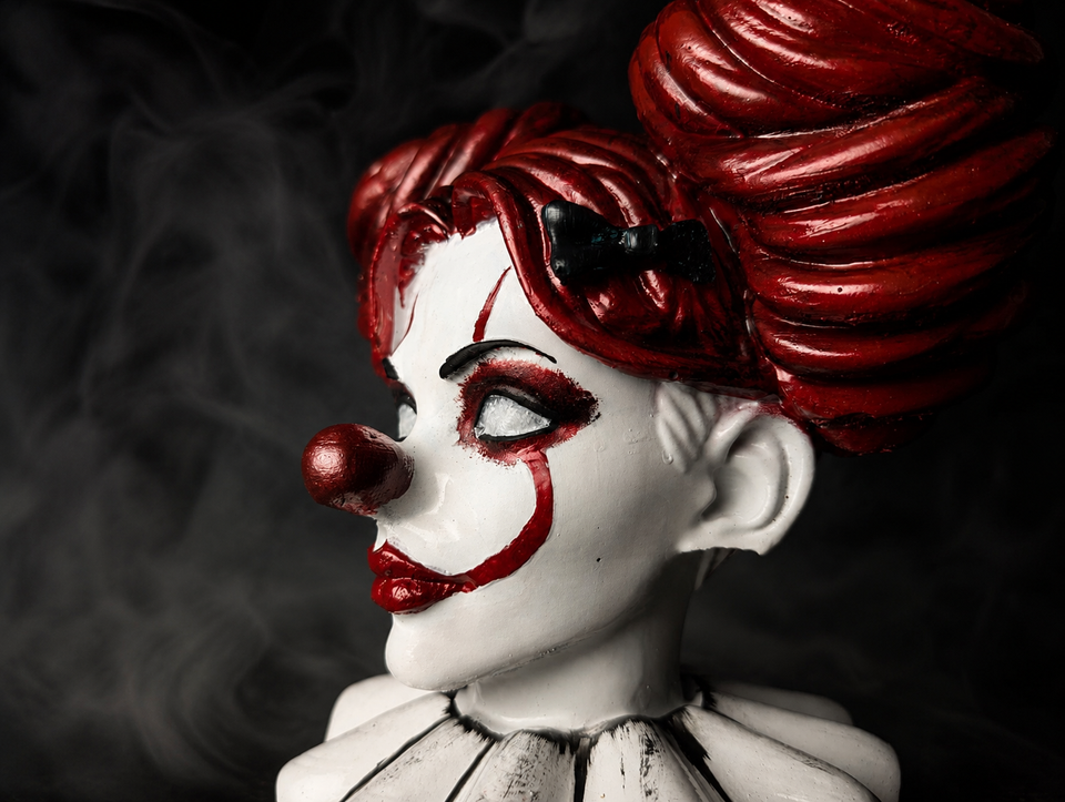 Close up of hand-painted clown face detail on a cast stone horror planter