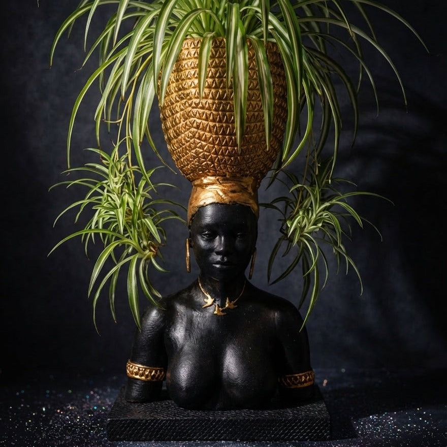 Harvest Goddess cast stone planter with spider plant against a black backdrop