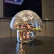 Large classic silver disco mushroom ornament on a dark tabletop