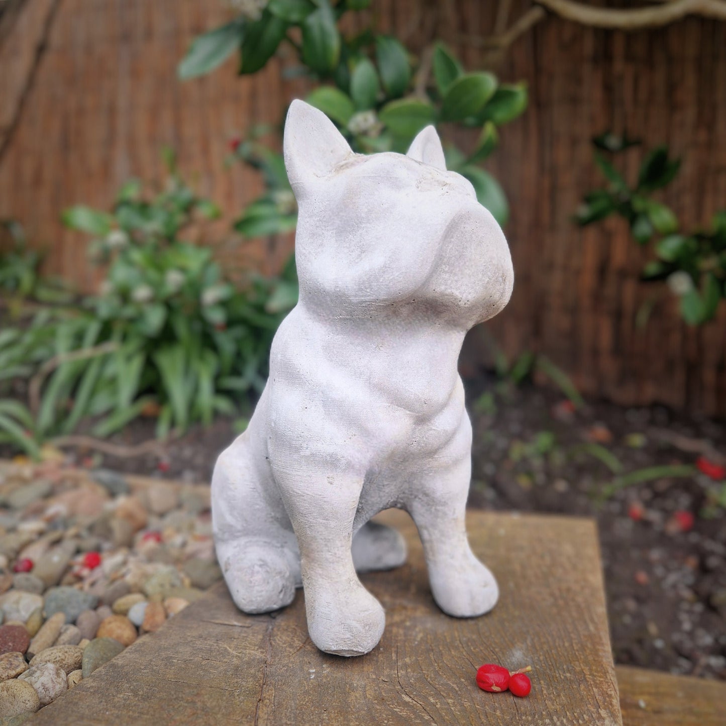 a white statue of a white dog on a stone wall 