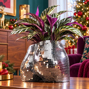 Pair of silver mirror mosaic torso planters with leafy plants on a purple studio backdrop