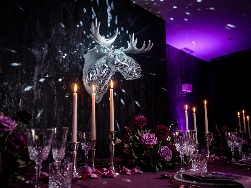 Mirrorball Moose displayed above a candlelit dining table with purple florals