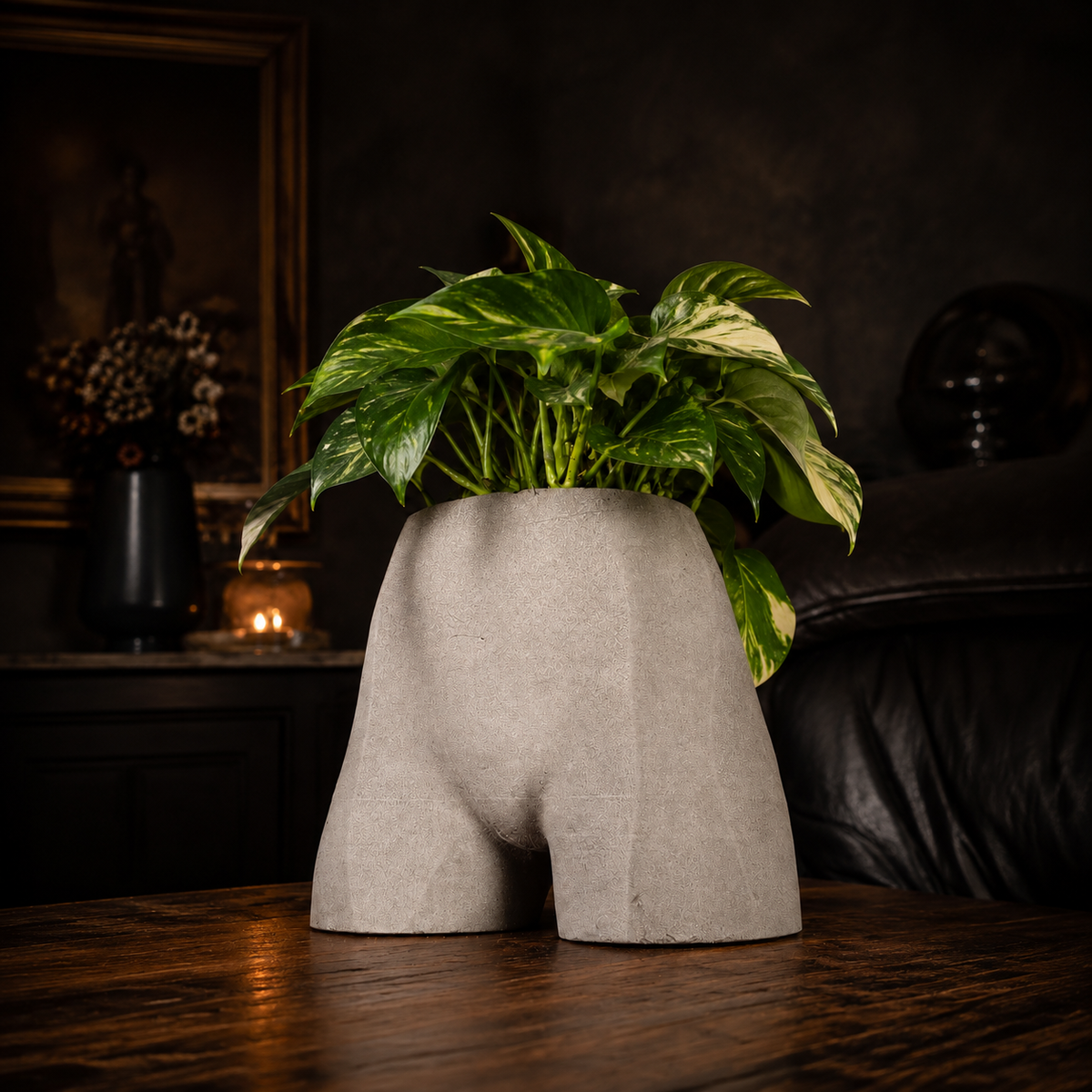 Front lifestyle view of Cheeky Bum cast stone planter with green houseplant