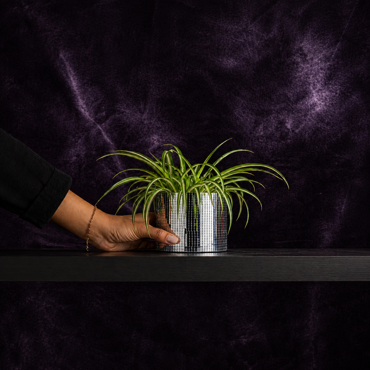 Small silver disco ball plant pot held in one hand for scale