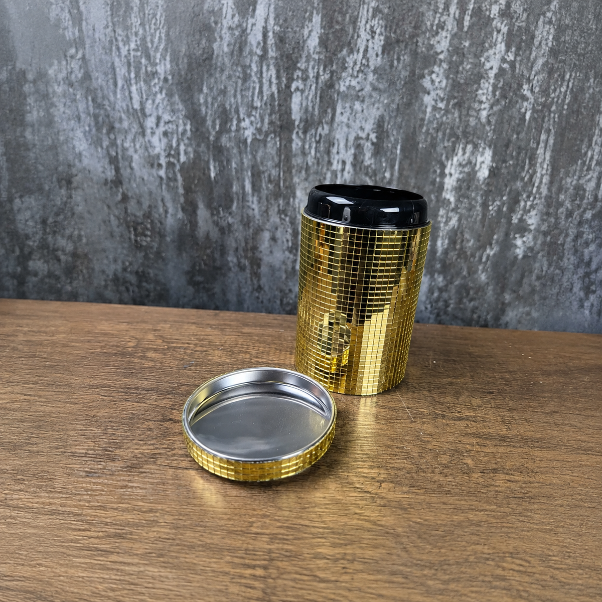 Open gold mirror canister with detached lid showing the metal interior
