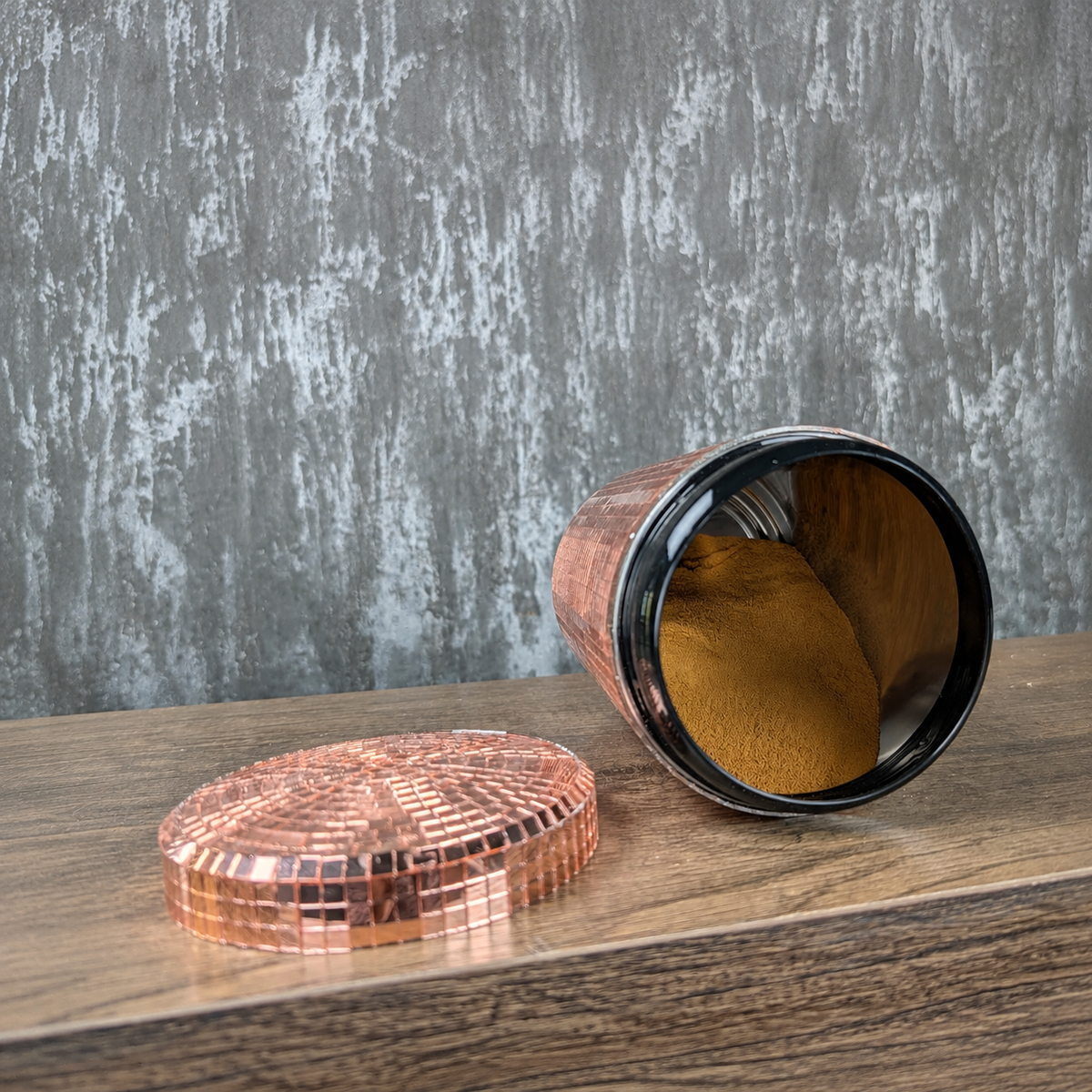 Open rose gold mirror canister with detached lid showing the metal interior