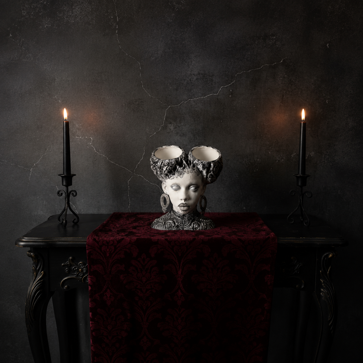 Unplanted gothic twin bowl head planter on red velvet between two candles