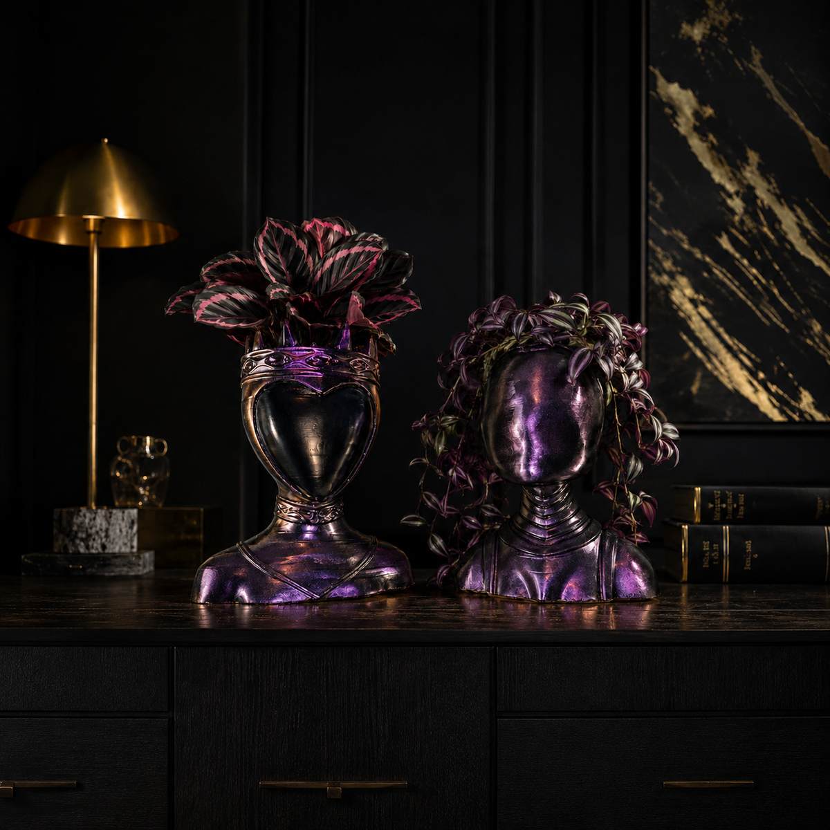 Queen and Oracle cast stone bust planters on dark interior shelf