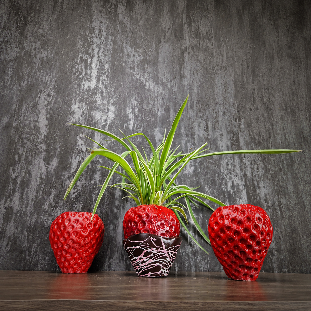Two red strawberry planters and a planted chocolate-dipped strawberry planter