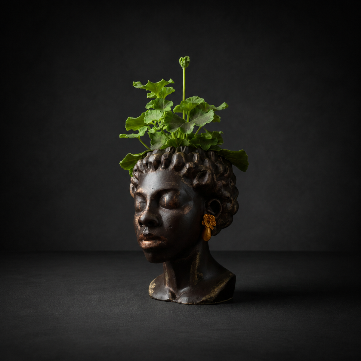 Three quarter view of cast stone bust planter with gold earrings