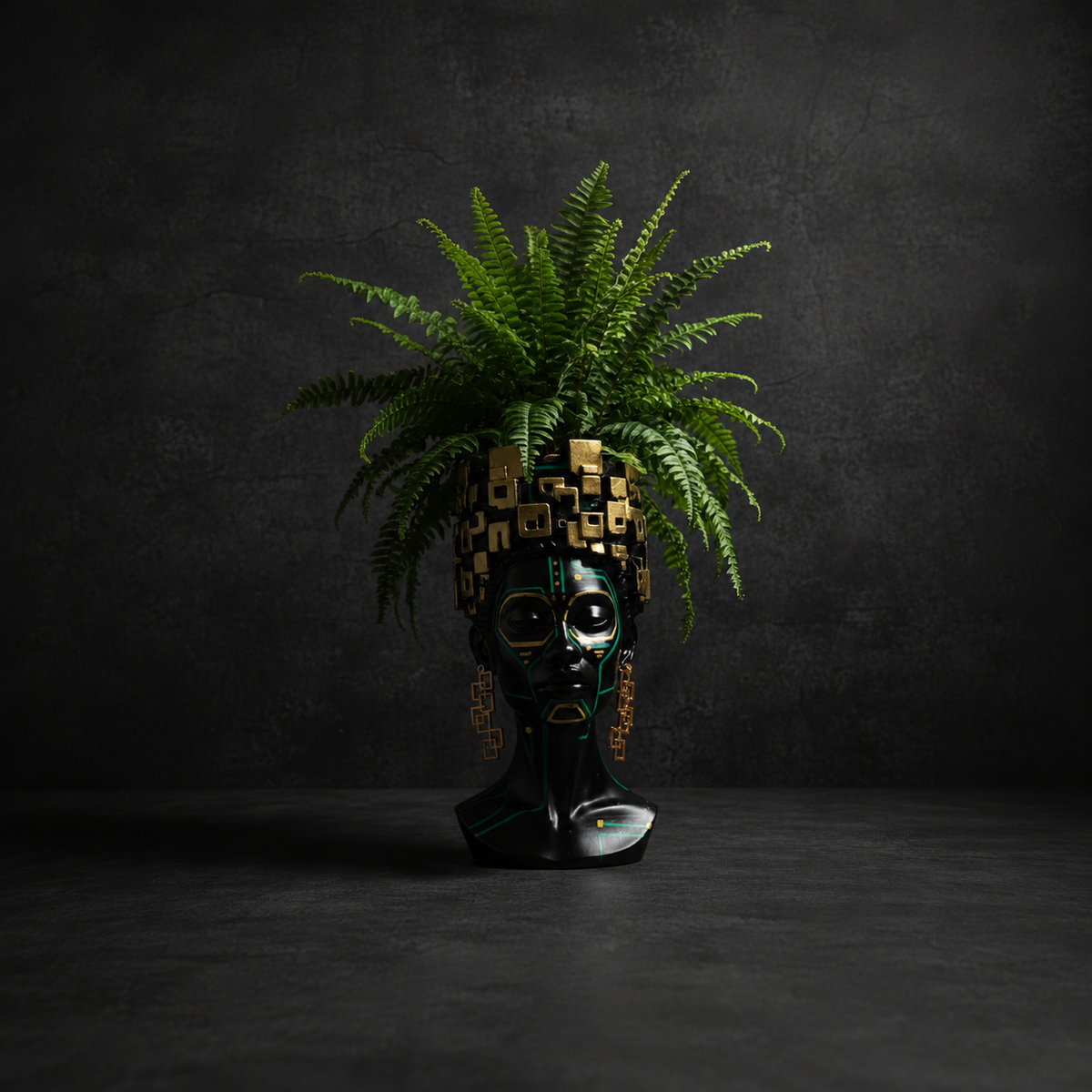 The Motherboard head planter with a fern on a dark studio background
