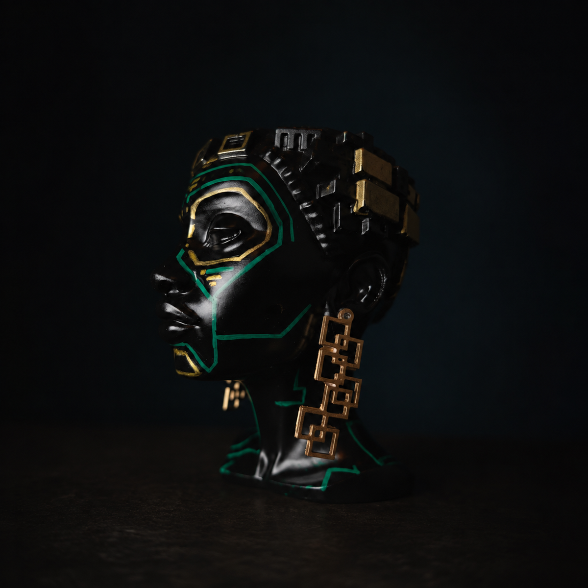 Close-up of The Motherboard head planter's gold geometric earring and teal face details