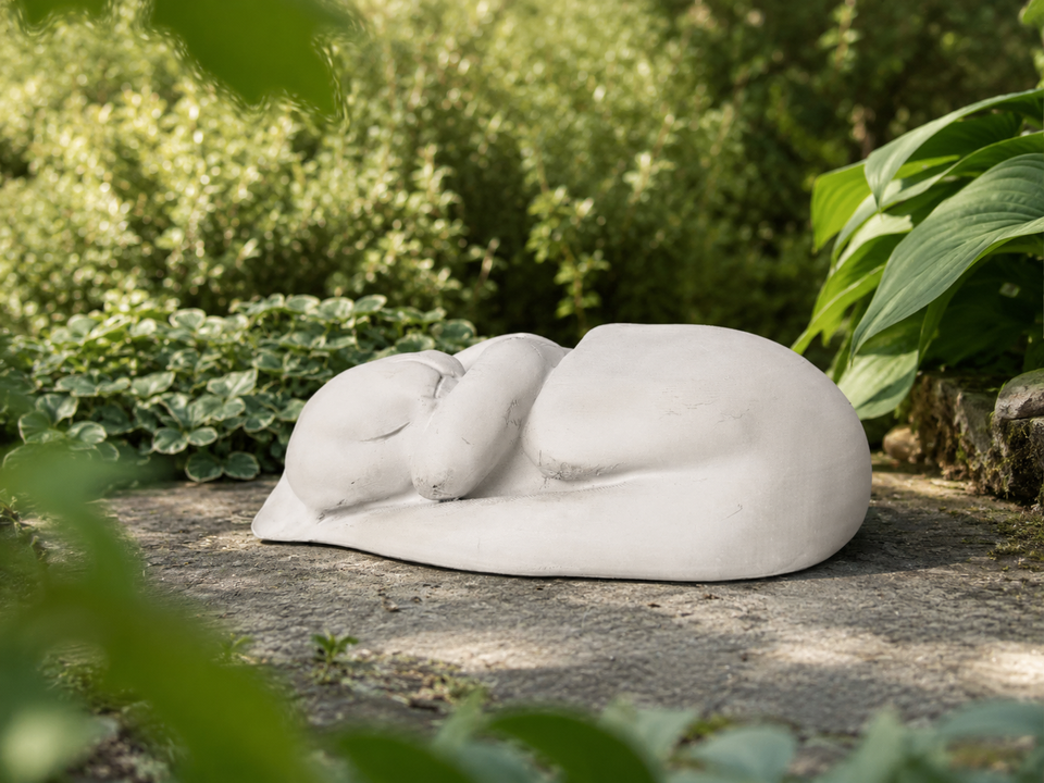 Sleeping Cat Garden Statue in a shaded garden setting