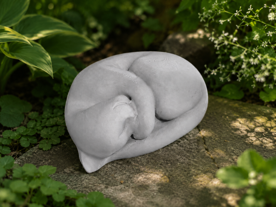 Sleeping Cat Garden Statue angled garden view among green planting