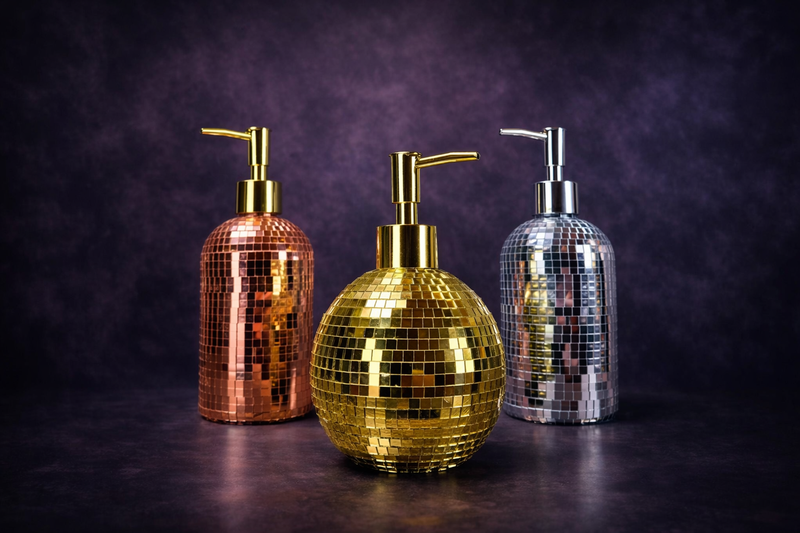 The Lather Ball mirror ball soap dispenser in gold on dark background